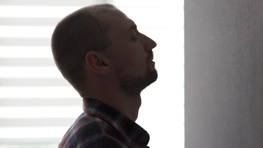 A lonely man leans his head against the wall, holding back his negative emotions. Problems with alcohol, drugs, bankruptcy, divorce from his wife.