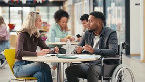 Two college or university students with one in wheelchair working together in study area - shot in slow motion - Powered by Shutterstock - Get 15% off with code: PIKWIZARD15