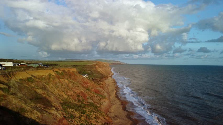 Video of the Cliffs at Grange Farm Campsite on the Isle of Wight. Footage moves out to sea and rotates around the beach capturing the waves crashing up on the stones.