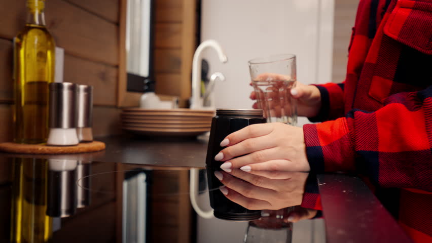 A young girl brews coffee early in the morning in a geyser turbine in the kitchen of her home