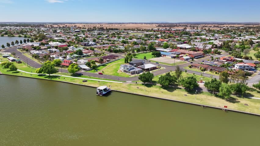 Over a tourist boat moored on the shore of Lake Mulwala with the town of Yarrawonga and farmland beyond