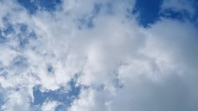 Hyperlapse time lapse video. White fluffy clouds floating in clear blue sky. Peace, tranquility, meditation. Strong wind 