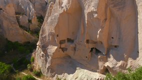 Embark on a visual journey with this mesmerizing aerial stock video capturing the essence of Cappadocia's cave dwellings near Goreme, Turkey. The bird's eye perspective unveils the unique charm of