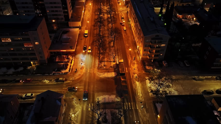 Aerial view tilting over traffic on the Kauppapuistikko esplanade, night in Vaasa, Finland