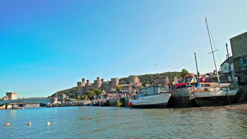 Panoramic view of Conwy Castle in Conwy, North Wales. Famous fortress with eight lofty towers and birds flying over River Conwy.