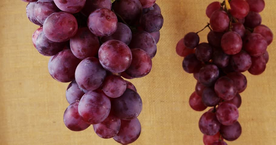 Grapes and bottles of wine on a burlap background.