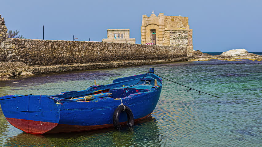 Wooden Boat With Ruins Of Torre di Ligny In The Background At Trapani, Sicily, Italy. Timelapse Royalty-Free Stock Footage #1111640035