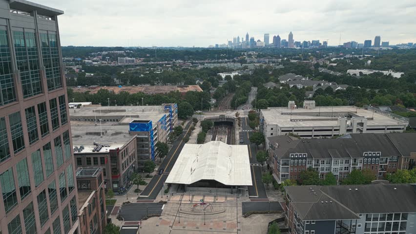 Aerial approaching shot of Lindbergh Marta Station and Skyline of Atlanta City in background during cloudy day