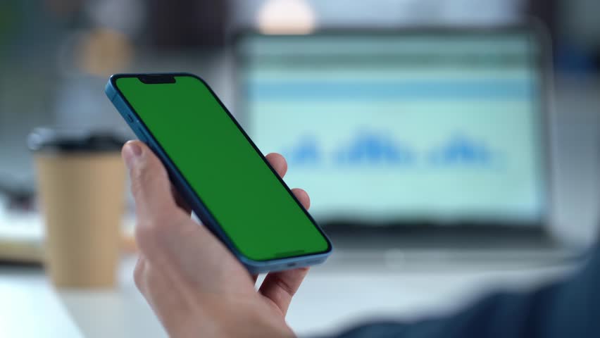 Close-up Of Smartphone With Green Mock-up Screen In Men's Hands On Desktop Background. Man Using Mobile Phone, Browsing Internet, Social Networks, Financial Reports. | Shutterstock HD Video #1111640803