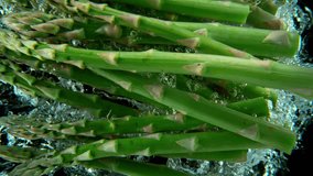 Super slow motion shot of falling asparagus into water, black background. Filmed on high speed cinematic camera at 1000 fps. - Powered by Shutterstock - Get 15% off with code: PIKWIZARD15