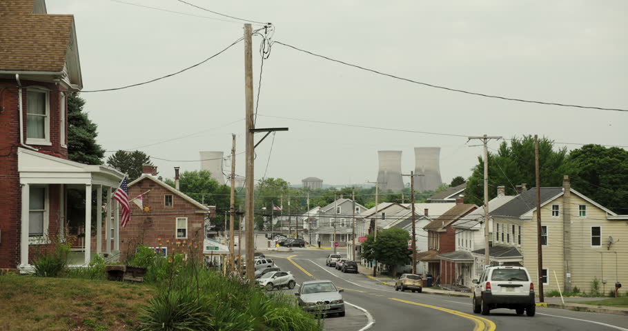 Car Travels Down Main Street Of Small Town In UsSA With Nuclear Plant In Distance Royalty-Free Stock Footage #1111647697