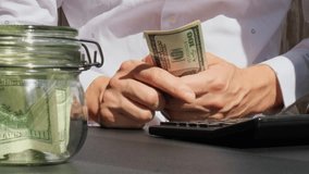 Expert trader hands showing Bitcoin coin digital gold after counting income banknotes of dollar cash on calculator. Close up of hands unrecognizable Freelancer. Earned trading charts growth - Powered by Shutterstock - Get 15% off with code: PIKWIZARD15