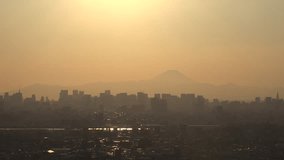 TOKYO, JAPAN : Aerial CITYSCAPE of TOKYO and MOUNT FUJI in sunset. View of buildings and street at downtown area. Japanese urban city life and nature concept video. 4K time lapse shot, dusk to night.