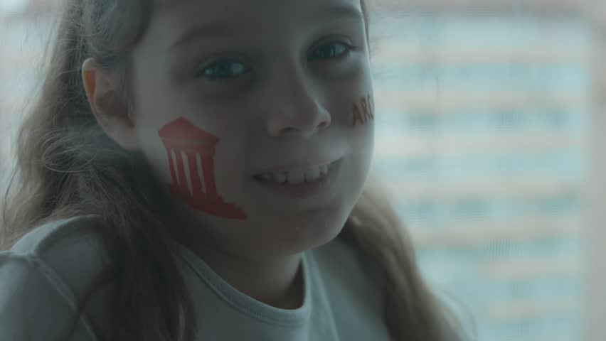 Cheerful cute little girl with ancient building drawing on her face and Architecture inscription. Architecture concept. Artistic effect