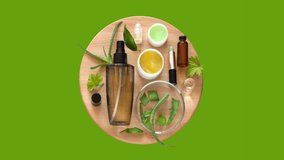 Video of cleansing anti-aging natural herbal cosmetics with aloe extract on wooden and green background. Advertising of new cosmetic products. Moisturizing skin care. Top view, closeup, flat lay