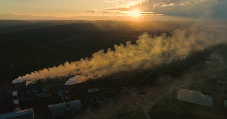 Factory Smokestack Spewing Out a Stream of Smoke. Plant Pipes Pollute the Atmosphere. Industrial Factory Pollution. Topics: carbon dioxide, CO2 gas. Setting Sun | Shutterstock HD Video #1111663343