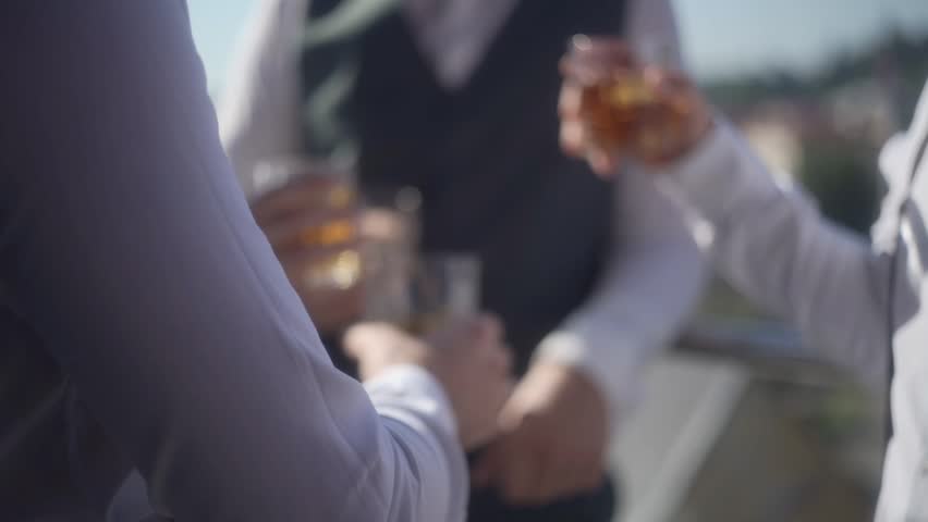 Mans is clinks glasses with whiskey on the party. Gentlemen in suits is to cheers on the event celebration. Slow motion footage. Royalty-Free Stock Footage #1111669279