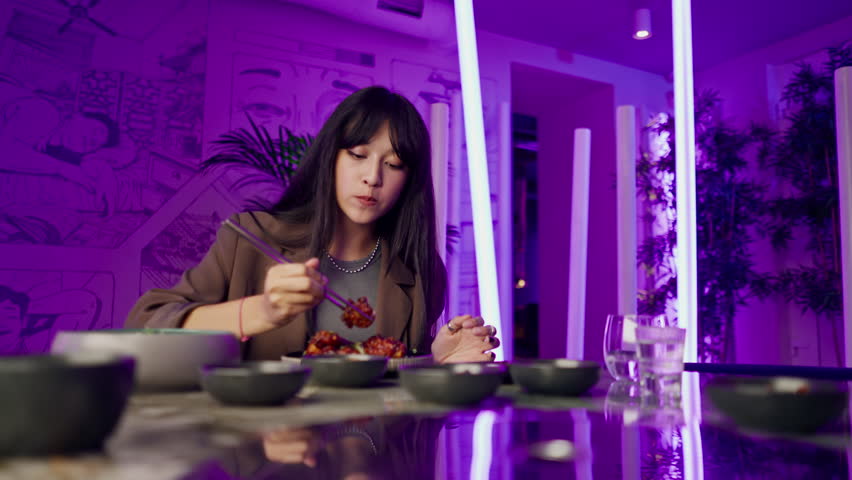 a beautiful young girl in a Korean restaurant is happy to try traditional dishes with unsurpassed taste