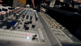 close-up shot of the male hand of a sound engineer switching settings on the mixing console for recording a soundtrack