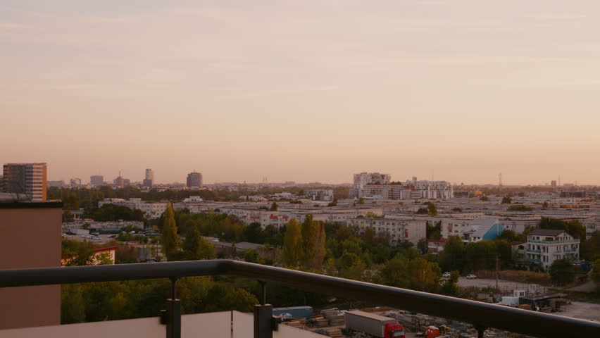 Woman coming to the balcony looking at the skyline. Medium shot of a pregnant woman on a balcony in the evening. | Shutterstock HD Video #1111680839