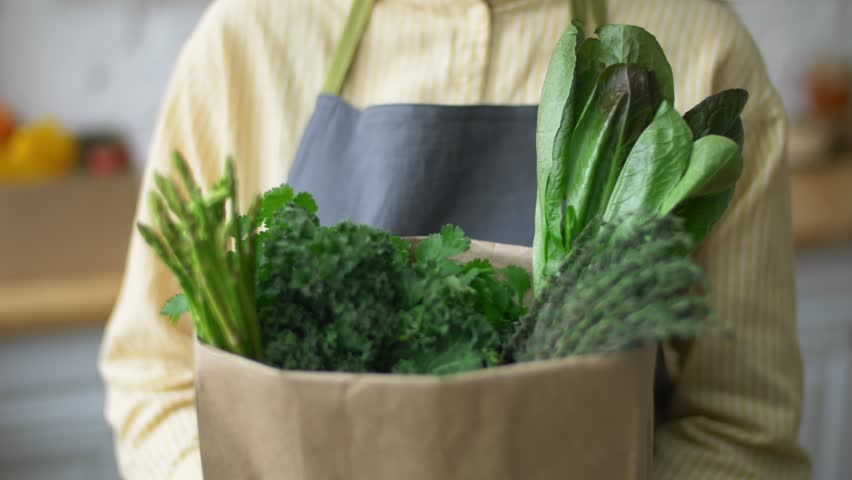 Greens in a paper bag, food delivery, organic grocery delivery service. online food stores. produce boxes from local farms. green asparagus in a brown paper bag. healthy eating concept | Shutterstock HD Video #1111683013
