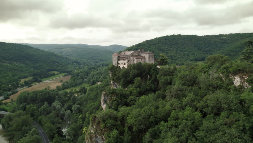 Aerial shot of the town of Bruniquel in the south of France. French village on a hill in the middle of the forest with a medieval castle on the edge of a cliff with a view of a river. Royalty-Free Stock Footage #1111685761