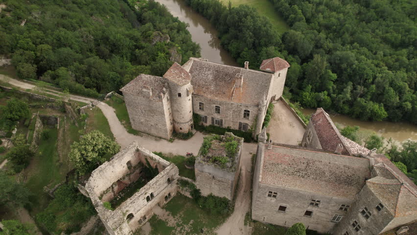 Aerial shot of the town of Bruniquel in the south of France. French village on a hill in the middle of the forest with a medieval castle on the edge of a cliff with a view of a river. Royalty-Free Stock Footage #1111685773