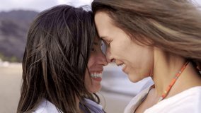 Gay lesbian female couple enjoy tender moment together outside with beach background. LGBTQ diversity and family love concept - Powered by Shutterstock - Get 15% off with code: PIKWIZARD15