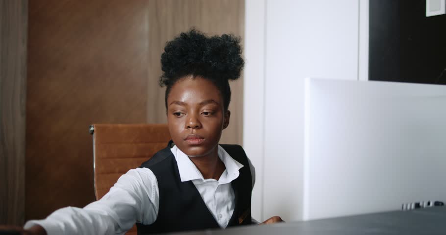 Portrait of busy accomplished woman working as a receptionist in hotel. Appealing female African-American receptionist taking calls and conversing on phone. Pleasant young hotel manager. Royalty-Free Stock Footage #1111688379