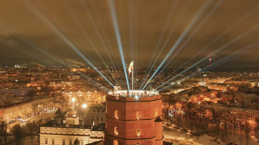 Scenic aerial orbit view of Gediminas tower in Vilnius Old Town beautifully illuminated for 700th birthday celebration. Main symbol of Lithuanian capital at winter night. Royalty-Free Stock Footage #1111688957
