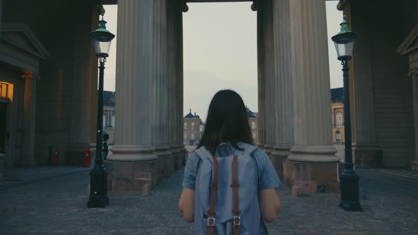 Camera follows young female traveler exploring Amalienborg castle in Copenhagen, Denmark. Royalty-Free Stock Footage #1111695007