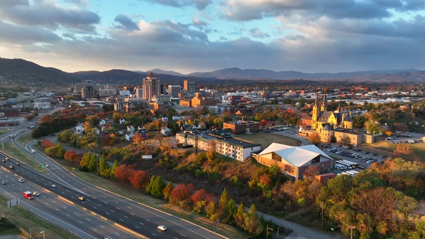 Roanoke, Virginia during golden hour sunrise. Aerial shot of Catholic cathedral and panning towards downtown skyline during autumn.