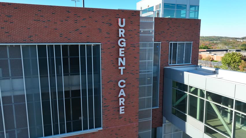 Urgent Care sign on modern brick medical center. Aerial establishing shot. Royalty-Free Stock Footage #1111697821