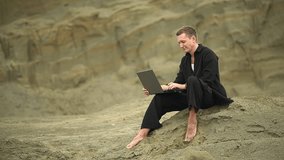man in the desert.man working on a laptop.slow motion video. High quality 4K footage