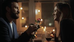 Date, Valentines Day, first date. Man during romantic candlelight dinner in restaurant or at home gives woman one rose - Powered by Shutterstock - Get 15% off with code: PIKWIZARD15