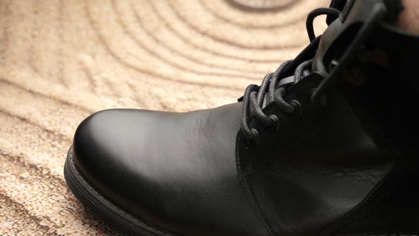 Black leather boots are cleaned with shoe cream. The concept of shoe care. | Shutterstock HD Video #1111707481