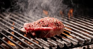 Close-up. Juicy piece of meat sizzles on grill, releasing irresistible smoky aroma that attracts everyone. Grill turns ordinary meat into extraordinary delicacies. Delicious summer treats. Copy space.