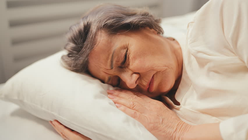 Sad senior woman waking up in bed, feeling strong migraine, health problems | Shutterstock HD Video #1111712261