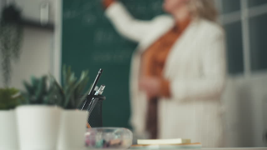 Woman geometry teacher explaining new material on chalkboard to students | Shutterstock HD Video #1111712283