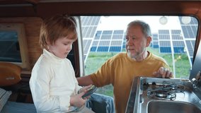 Grandpa and grandson with gadget in eco-friendly RV. Teaching and bonding during family outdoor vacation. - Powered by Shutterstock - Get 15% off with code: PIKWIZARD15