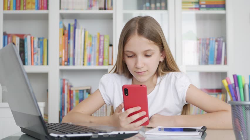 Girl Child Using Smartphone Studying in Video Conferencing, Kid Learning, Writing in Library, Schoolgirl Chatting, Online Education Royalty-Free Stock Footage #1111717559