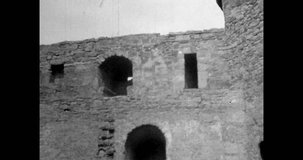 Stone walls ancient ruined castle inside. Medieval building ruins. Historic fortification architecture. Fortress landmark. Archival vintage black white film. Old retro archive video. 1980s Crimea
