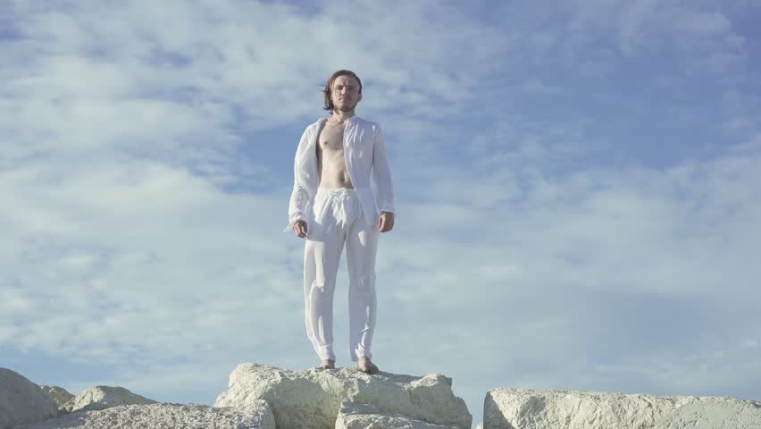 Man standing in the wind in white suit