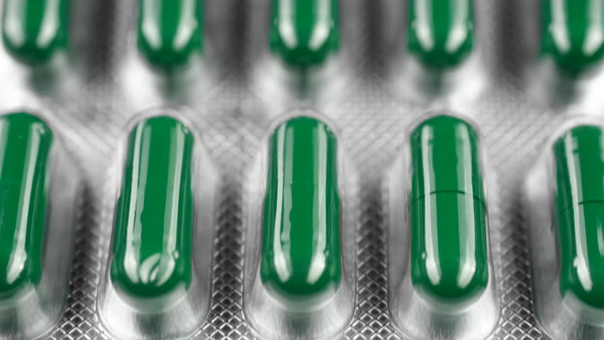 Green capsule pills in blister pack, slider shot