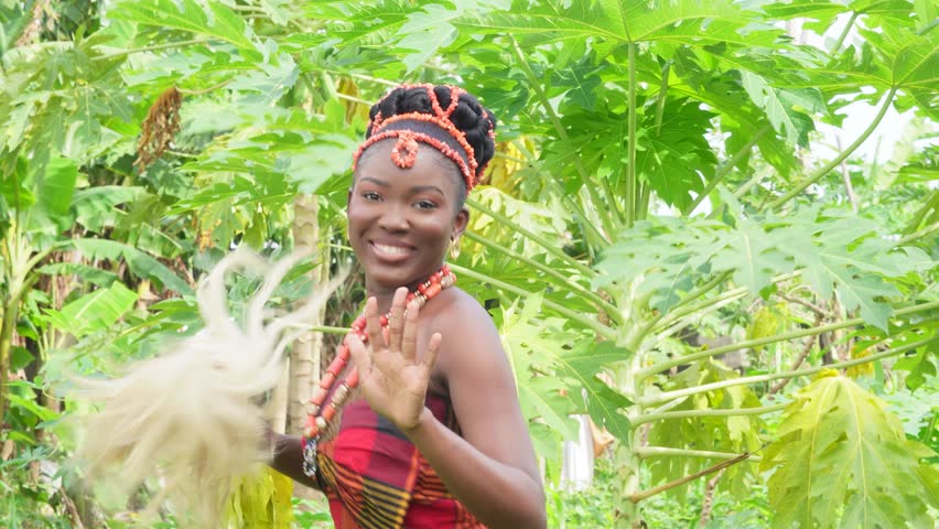 young black igbo looking gorgeous wearing native attire up wearing beads and dancing traditional cow tail
