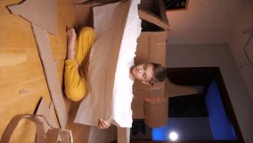 vertical video boy builds a spaceship out of cardboard