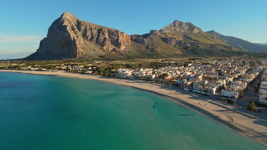 Aerial shot of famous San Vito Lo Capo - beach and town in Sicily, Italy. Beach with turquoise water at the foot of the mountain in San Vito Lo Capo - tourist pearl of western Sicily Royalty-Free Stock Footage #1111726461