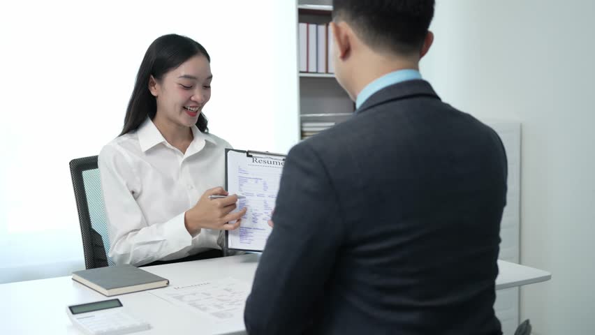 A successful businessman interviews a smart young woman for work in a respectful, professional atmosphere with a busy conversation. Two sides in modern office Royalty-Free Stock Footage #1111732337