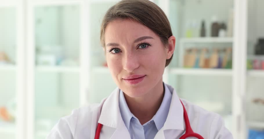 Beautiful female doctor holds red hearts with her hands and closes eye. Positive female medic caring about heart health Royalty-Free Stock Footage #1111733651
