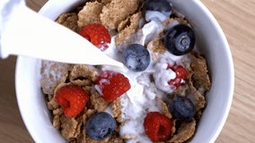Morning Delight in Slow Motion - Pouring Milk Over Wheat Cereal with Berries, High-Speed Capture from above angle. - Powered by Shutterstock - Get 15% off with code: PIKWIZARD15